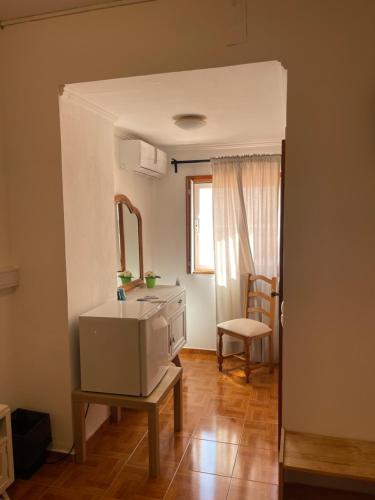 een woonkamer met een wastafel en een spiegel bij Dona Ana Pensão Residencial in Lagos