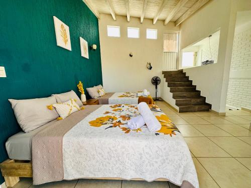 - une chambre avec 2 lits et un mur bleu dans l'établissement Casa Rinconcito Del Sol Con Alberca, à Tonatico