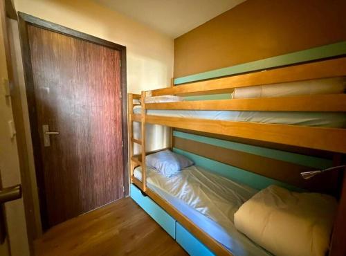 a room with two bunk beds and a door at Mandelieu / Appart Climatisé 4 prsn RDC / Piscine in Mandelieu-La Napoule