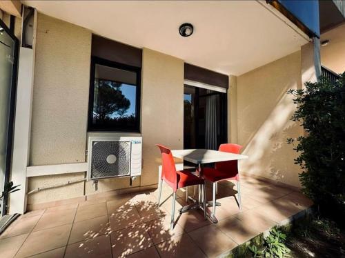 un patio avec une table, des chaises et une fenêtre dans l'établissement Mandelieu / Appart Climatisé 4 prsn RDC / Piscine, à Mandelieu-la-Napoule