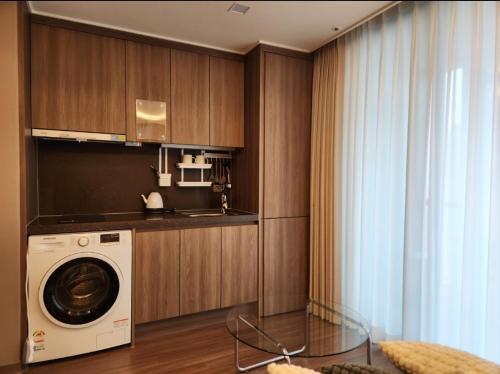 uma cozinha com uma máquina de lavar roupa num quarto em La Elbon stay in Haewoondae beach em Busan