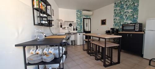 - une cuisine avec un comptoir et quelques tables et chaises dans l'établissement Maison centre Historique, à Saint-Gilles