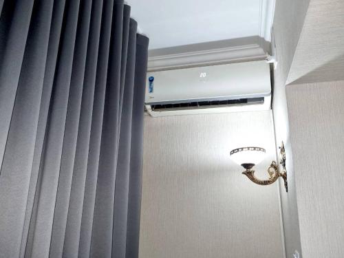 a light in the corner of a room with curtains at City Center Apartment 1 in Tashkent