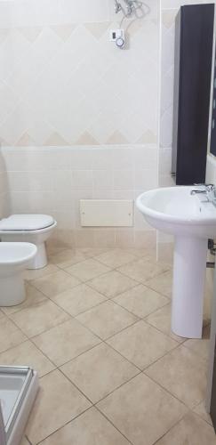 a bathroom with a toilet and a sink at CasaAlma in Serdiana