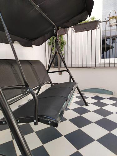 a black chair sitting on top of a checkered floor at LianHome b&b "Terrazzino" in Lucera