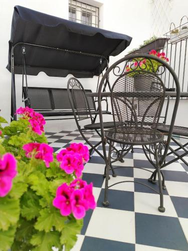 a black chair sitting on a porch with pink flowers at LianHome b&b "Terrazzino" in Lucera