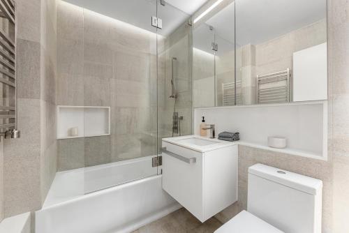 a white bathroom with a toilet and a shower at Delancey Tower in New York