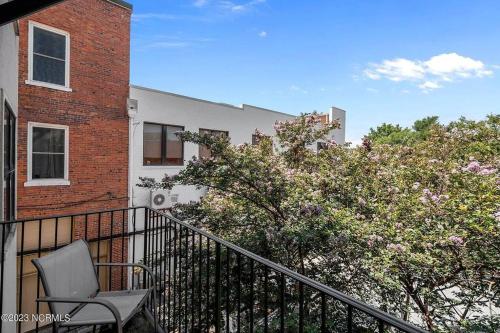 a chair sitting on a balcony next to a building at Downtown Condo*Balcony*River*Pet Friendly*Beach in Wilmington