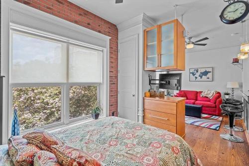 a bedroom with a bed and a red couch at Downtown Condo*Balcony*River*Pet Friendly*Beach in Wilmington