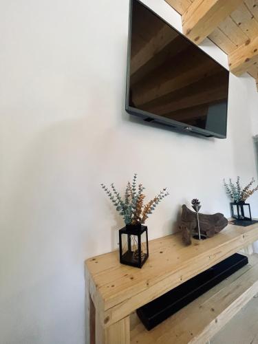a room with a wooden table with a tv on the wall at Hill House SD in Topliţa