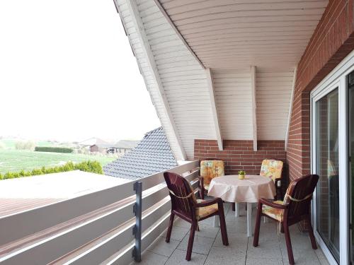 a patio with a table and chairs on a balcony at Ferienwohnung Seeblick in Neu Schloen