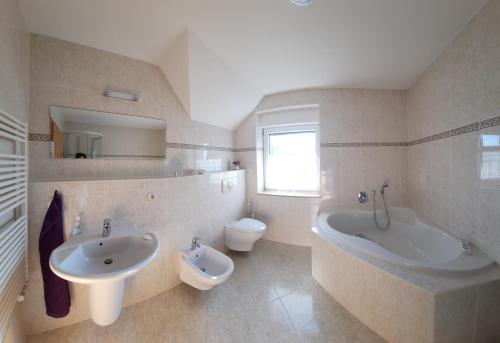 Neu SchloenにあるFerienwohnung Seeblickのバスルーム(シンク、バスタブ、トイレ付)
