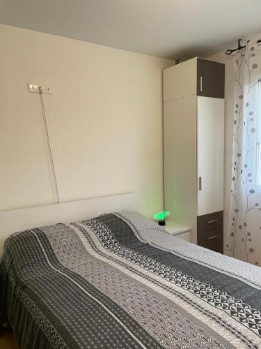 Schlafzimmer mit einem Bett, einer Kommode und einem Kühlschrank in der Unterkunft Cosy studio, lit double in Le Mans