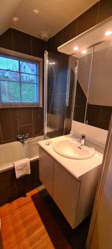 une salle de bain avec un lavabo, une baignoire et un miroir dans l'établissement Le cottage sauvage, à Équihen-Plage