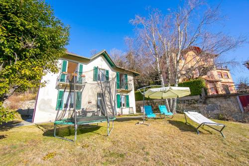 a house with two chairs and an umbrella in the yard at Mila Bike with wi-fi - Happy Rentals in Premeno