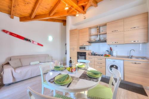 eine Küche und ein Wohnzimmer mit einem Tisch und Stühlen in der Unterkunft La Brezza Del Lago Maggiore with view - Happy Rentals in Laveno-Mombello