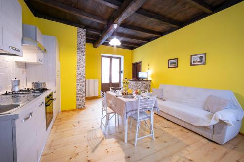 een keuken en een woonkamer met een tafel en een bank bij Petit Coeur Dans L' Ancien Village - Happy Rentals in Brovello-Carpugnino
