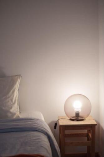 une lampe sur une table de nuit à côté d'un lit dans l'établissement Home Mais Sant’Ana, à Lisbonne