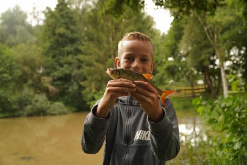 a young boy holding a fish in his hands at Plezant in de Fazant in Diffelen