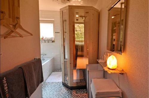 y baño con bañera, lavabo y espejo. en Gästehaus Resi, en Jerzens
