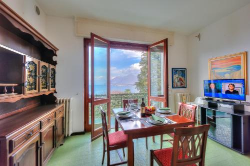 a dining room with a table and a large window at La Finestra Sul Lago - Happy Rentals in Stresa