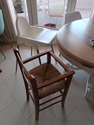 a wooden chair next to a table and a table and chairs at Casa degli Aromi in Lucca