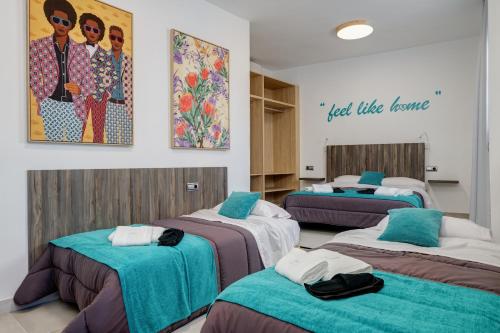 Cette chambre comprend 4 lits avec une photo sur le mur. dans l'établissement Penthouse Apartment Tribuna Center By Seric,15' walking to the beach, à Malaga