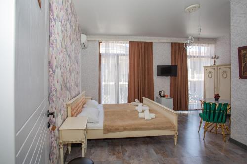 a bedroom with a bed with white pillows on it at Hotel Homeland in Batumi