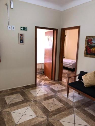 a living room with a couch and a room with a bedroom at Pousadaa São João 144 in Aparecida