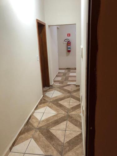 a hallway with a tile floor and a fire hydrant at Pousadaa São João 144 in Aparecida