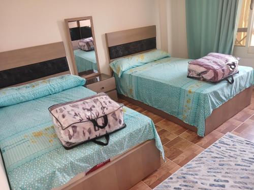 a bedroom with two beds with a suitcase on them at كمبوند سيتي تاورز مدينة نصر حي الواحه in Cairo