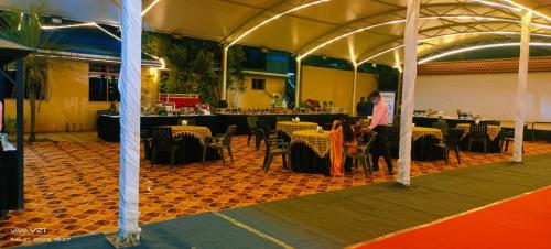 Tienda con mesas y sillas en una habitación en JVS BEAUTY GREEN RESORT en Venkatāpur