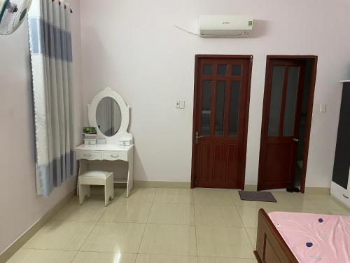 a bathroom with a sink and a mirror and a door at Nhà Nghỉ 846-B44 in Vung Tau