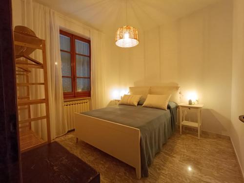 a bedroom with a bed and a window and a chandelier at CASA TARTARUGA in La Spezia