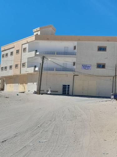 a large white building in front of a building at Suites & apartments Fderik in Nouadhibou