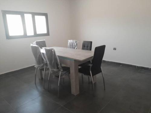 a wooden table and chairs in a room at Suites & apartments Fderik in Nouadhibou