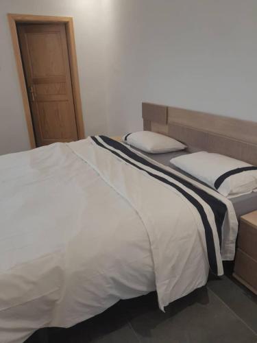 a bedroom with two beds with white and black sheets at Suites & apartments Fderik in Nouadhibou