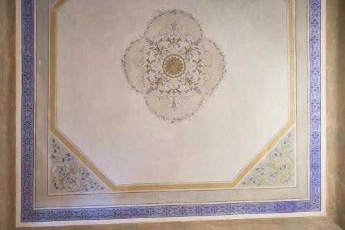 a white wall with a blue and gold painting on it at Affittacamere San Teodoro in Albenga