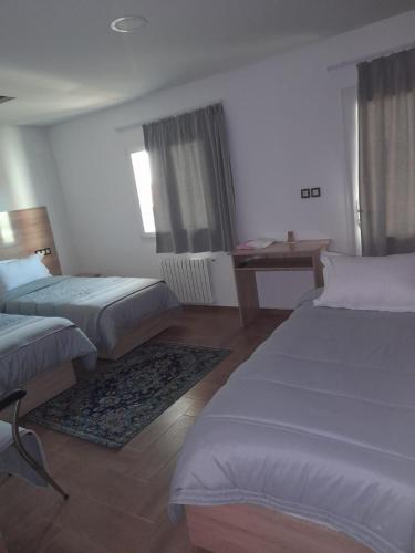 a hotel room with two beds and a desk at AUBERGE JOMANA PARK in Azrou