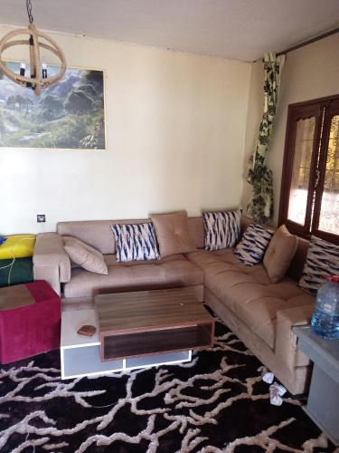 a living room with a brown couch and a coffee table at ضاية رومي in Dar Caïd Bou Driss