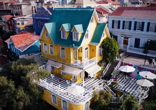 an aerial view of a large yellow house with a blue roof at Hotel Brighton in Valparaíso