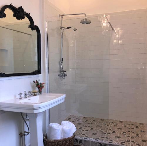 a white bathroom with a sink and a shower at La Pommeraie Champsecret, Lower Normandy in Champsecret