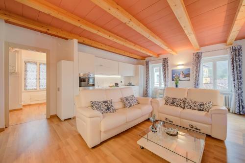 ein Wohnzimmer mit 2 weißen Sofas und einem Tisch in der Unterkunft Concordia Apartment Laveno - Happy Rentals in Laveno