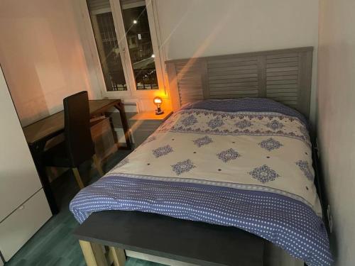 - un lit dans une chambre avec une table et une fenêtre dans l'établissement Appartement les Lilas, aux Lilas