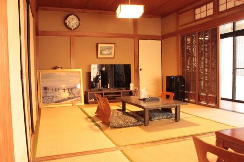 uma sala de estar com uma mesa e uma televisão em Rental villa Saya - Vacation STAY 85439v em Chigasaki