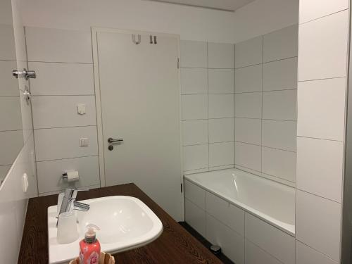 a bathroom with a sink and a bath tub at Apartmenthaus Hafenspitze Ap 28, Blickrichtung InnenstadtBinnenhafen - a72338 in Eckernförde