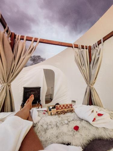 a person laying on a bed in a tent at The Bubble Valley clarens in Clarens