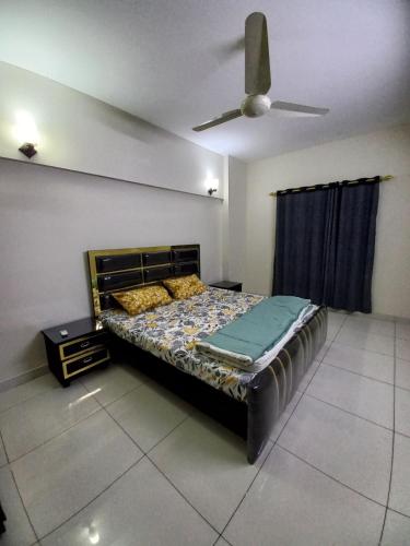 a bedroom with a bed and a ceiling fan at Modern Luxury Guest Apartment With All Facilities in Karachi