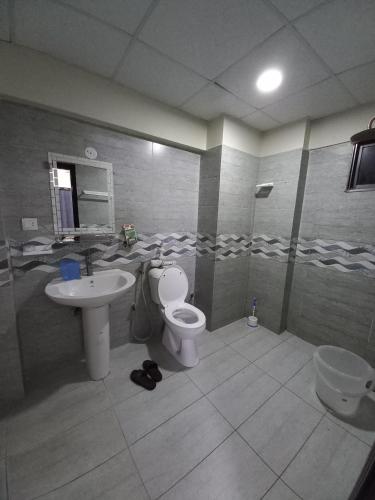 a bathroom with a toilet and a sink at Modern Luxury Guest Apartment With All Facilities in Karachi