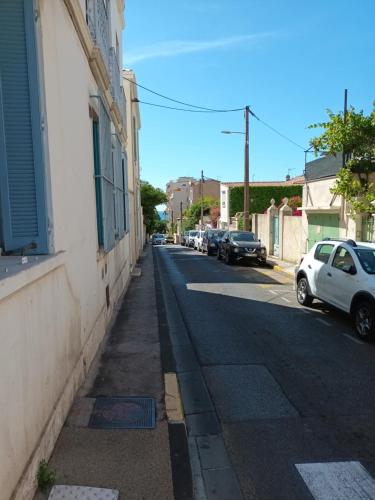 une rue avec des voitures garées sur le côté d'un bâtiment dans l'établissement Studios à 50 m des plages du Mourillon, à Toulon
